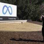Un empleado de Facebook toma una foto del logotipo de Meta en Menlo Park, California
