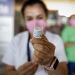 AME5739. ASUNCIÓN (PARAGUAY), 09/11/2021.- Una integrante del personal de salud prepara una dosis de vacuna contra la covid-19 hoy en el puesto de vacunación en la Terminal de Ómnibus de Asunción (Paraguay). Decenas de personas se vacunan este martes en el puesto de vacunación de la Terminal de Ómnibus de Asunción. En dicho puesto los profesionales de la salud aplican la primera dosis de las vacunas Pfizer y AstraZeneca a personas de 30 años en adelante. EFE/Nathalia Aguilar