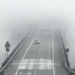 Un vehículo circula por Ponferrada ante una espesa niebla