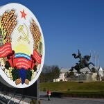 Imagen del escudo transnistrio y al fondo la estatua ecuestre de Alexandr Suvórov, el legendario general ruso que fundó Tiráspol, en la plaza central de la capital de la autoproclamada República de Transnistria