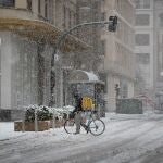 Un repartidor de comida a domicilio camina con su bicicleta por la calle Cortes de Navarra de Pamplona