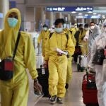 Pasajeros en el aeropuerto de Corea del Sur protegidos con trajes especiales por el coronavirus