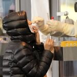 Un sanitario realiza un test de coronavirus a una mujer en Seúl, Corea del Sur