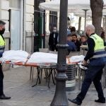 Operarios del retén fúnebre sacan el cadáver de mujer de 30 años de edad que ha sido encontrada este sábado en una vivienda de València asesinada presuntamente a manos de un hombre con el que mantenía una relación sentimental