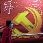 Una mujer pasa ante un cartel conmemorativo de los 100 años del Partido Comunista Chino en Hong Kong