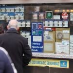 Varias personas en una administración de lotería de Navidad de la Puerta del Sol cuando queda una semana para el Sorteo Extraordinario de la Lotería de Navidad