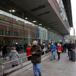 Diversas personas hacen cola a las puertas del recinto Wizink Center donde se administran las vacunas frente a la Covid-19 en plena sexta ola