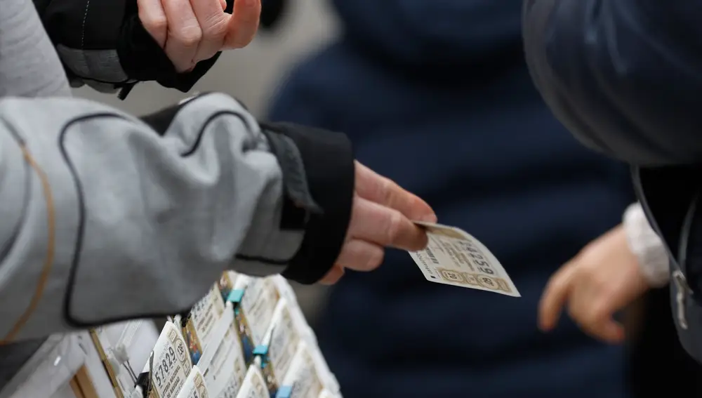 Una personas compra un décimo de lotería de Navidad a una vendedora ambulante cuando quedan menos de tres semanas para el Sorteo Extraordinario de la Lotería de Navidad, a 7 de diciembre de 2021, en Madrid (España). Como cada año, la Lotería de Navidad se celebra el próximo 22 de diciembre en el Colegio de San Ildefonso. Este año el sorteo repartirá un total de 2.408 millones de euros, la misma cantidad que el año anterior. El primer premio, denominado ‘El Gordo’, será de 400.000 euros.07 DICIEMBRE 2021;PREMIO;22 DE DICIEMBRE;NAVIDAD;SORTEO DE NAVIDAD;BOLETOS;NUMEROS;LOTERIA;DINEROEduardo Parra / Europa Press07/12/2021