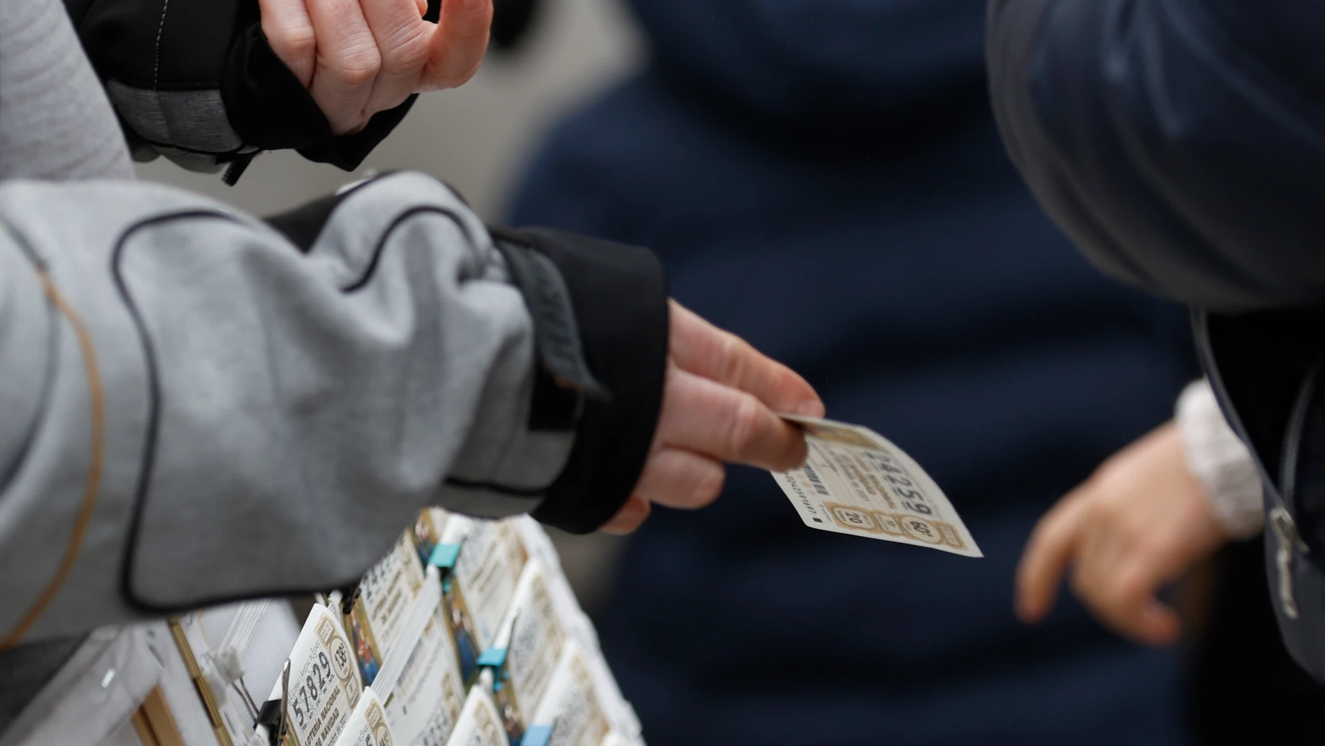 Una personas compra un décimo de lotería de Navidad a una vendedora ambulante cuando quedan menos de tres semanas para el Sorteo Extraordinario de la Lotería de Navidad, a 7 de diciembre de 2021, en Madrid (España). Como cada año, la Lotería de Navidad se celebra el próximo 22 de diciembre en el Colegio de San Ildefonso. Este año el sorteo repartirá un total de 2.408 millones de euros, la misma cantidad que el año anterior. El primer premio, denominado ‘El Gordo’, será de 400.000 euros.07 DICIEMBRE 2021;PREMIO;22 DE DICIEMBRE;NAVIDAD;SORTEO DE NAVIDAD;BOLETOS;NUMEROS;LOTERIA;DINEROEduardo Parra / Europa Press07/12/2021