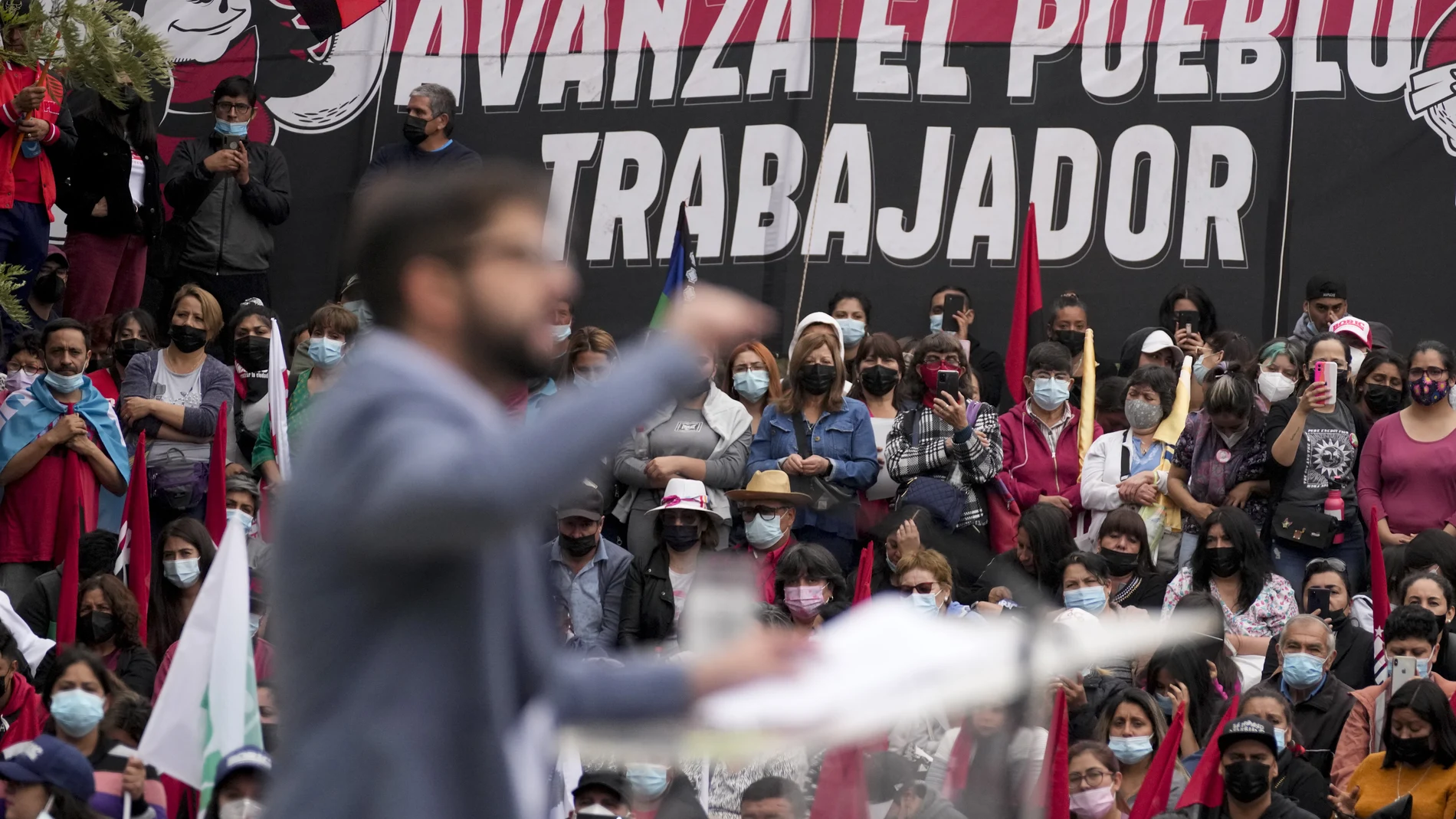 Followers listen to Chile's Presidential candidate Gabriel Boric from the Apruebo Dignidad coalition party, during a rally in Santiago, Chile, Saturday, Dec. 11, 2021. Chile heads to a presidential runoff on Dec. 19 between Boric and Jose Antonio Kast from the Partido Republicano. (AP Photo/Esteban Felix)