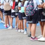Un grupo de niños esperan a entrar en un colegio de Primaria.