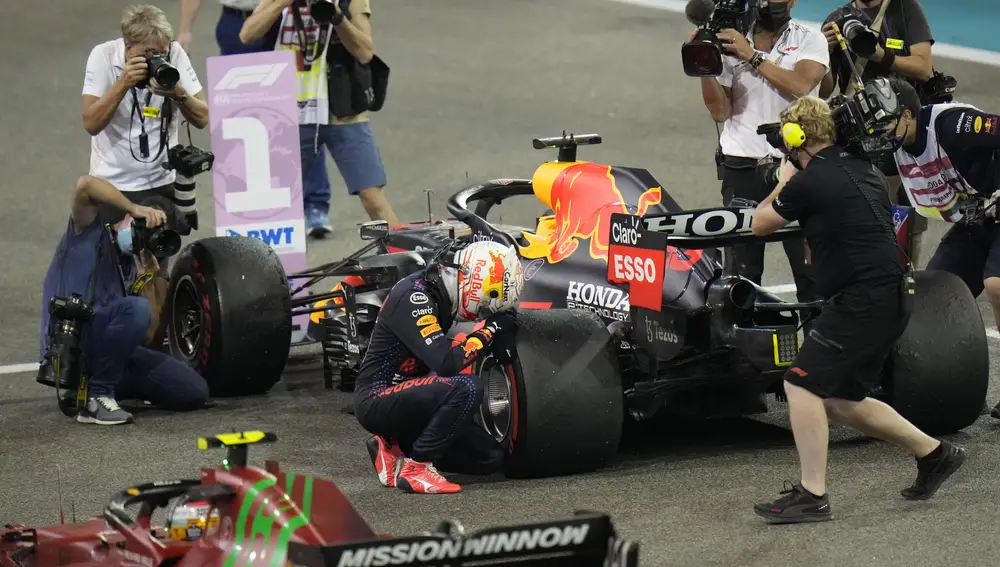 Red Bull driver Max Verstappen of the Netherlands kneels next to his car after he became the world champion after winning the Formula One Abu Dhabi Grand Prix in Abu Dhabi, United Arab Emirates, Sunday, Dec. 12, 2021. (AP Photo/Hassan Ammar)