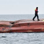 Un miembro de salvamento marítimo camina sobre el casco del carguero danés Karin Hoej volcado tras colisionar con el carguero británico Scot Carrier en el Mar Báltico