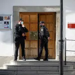 Miembros de la Policía Local d San Martín de Valdeiglesias vigilan el acceso al consistorio mientras integrantes del grupo de intervención de delitos financieros de la Guardia Civil registran la sede del Ayuntamiento