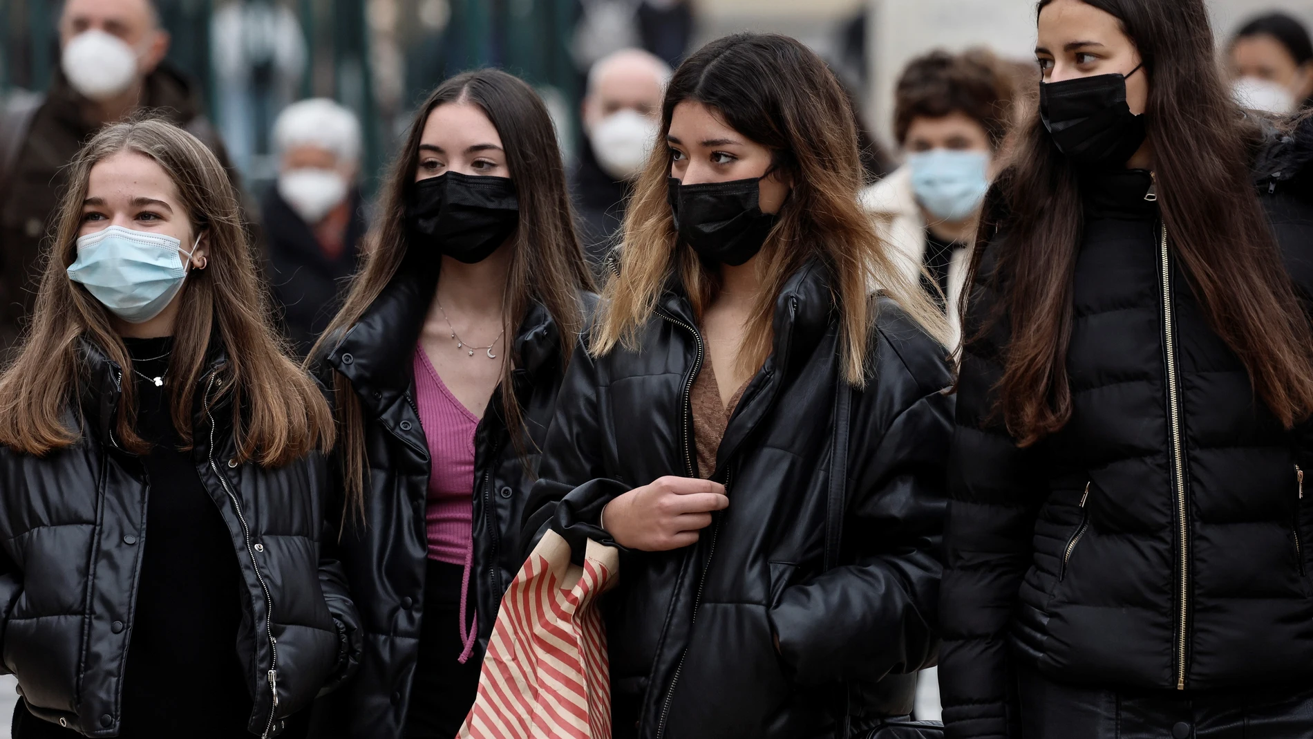 Varias personas caminan por la calle con mascarilla por las calles de Valencia