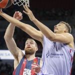 Matt Costello intenta evitar la canasta a aro pasado de Dante Exum