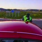 Un agente detiene a un coche durante un control de la Guardia Civil.