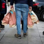 Una persona con bolsas en una calle comercial