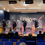 Operarios muestran el número del primer premio del sorteo extraordinario de lotería del Niño