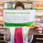 Una farmacéutica muestra un test de antígenos en una farmacia