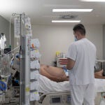 Un sanitario atiende a un paciente ingresado en la UCI del Hospital Isabel Zendal de Madrid