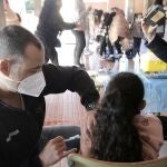 Una niña recibe la vacuna contra el Covid-19, en el CEIP Lucentum, hoy 13 de enero de 2022.