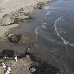 Workers clean up an oil spill at Cavero beach in Ventanilla, Callao, Peru, Monday, Jan. 17, 2022. Unusual high waves that authorities attribute to the eruption of the undersea volcano in Tonga caused the spill on the Peruvian Pacific coast as a ship was loading oil into La Pampilla refinery on Sunday. (AP Photo/Martin Mejia8