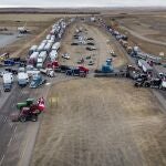 Anti-COVID-19 vaccine mandate demonstrators gather as a truck convoy blocks the highway at the busy U.S. border crossing in Coutts, Alberta, Canada, Monday, Jan. 31, 2022. (Jeff McIntosh/The Canadian Press via AP)