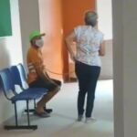 El hombre que llevaba mascarilla, aparece sentado, mientras su mujer está de pie y con una de sus manos lo sujeta con la cuerda.