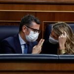 El ministro de Presidencia, Félix Bolaños (i), conversa con la ministra de Trabajo, Yolanda Díaz (d), durante el debate de la reforma laboral