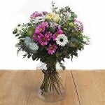 Ramo de flores frescas compuesto por crisantemos fucsia, brássicas, limonium y germinis blancos, y santinis verdes