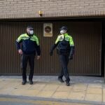 Dos agentes de la Policia Local de Totana (Murcia) custodian la puerta del garaje de la calle de la Rambla número 7 donde este miércoles ha aparecido, en el interior de un trastero, el cadáver de una joven de 17 años que llevaba 24 horas desaparecida.