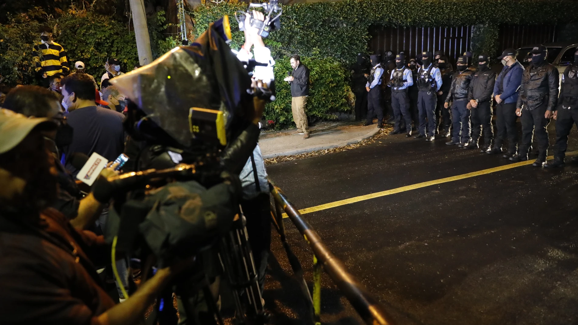 Agentes policiales rodean hoy la residencia del expresidente hondureño Juan Orlando Hernández, mientras periodistas realizan cubrimiento en Tegucigalpa (Honduras)