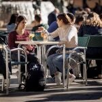 Varias personas disfrutan de un soleado día de invierno en una terraza en la ciudad de Valencia