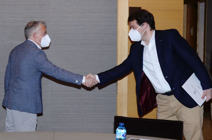 El candidato del PP a la presidencia de la Junta de Castilla y León, Alfonso Fernández Mañueco (d), saluda al candidato de Soria ¡Ya!, Ángel Ceña, en su primera reunión