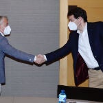 El candidato del PP a la presidencia de la Junta de Castilla y León, Alfonso Fernández Mañueco (d), saluda al candidato de Soria ¡Ya!, Ángel Ceña, en su primera reunión