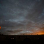 Varias personas caminan por el puente Romano de Córdoba y junto a la torre de la Calahorra en un jornada de cielos muy nubosos. EFE/Salas