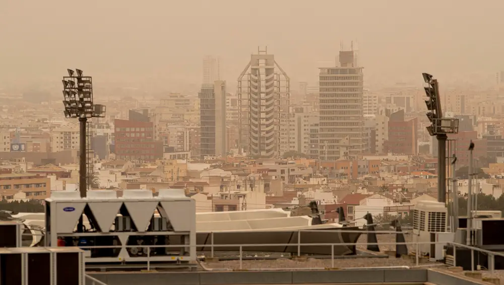 Vista de la ciudad de Murcia cubierta con una neblina de color rojo por el alto número de partículas y polvo en suspensión este martes. La llegada de una lengua de polvo en suspensión procedente del desierto del Sáhara, impulsada por los vientos de la borrasca Celia, ha elevado a la categoría de "extremadamente desfavorable" la calidad del aire en amplias zonas del país, por los altos niveles de concentración de partículas PM10, afectando seriamente a la salud.