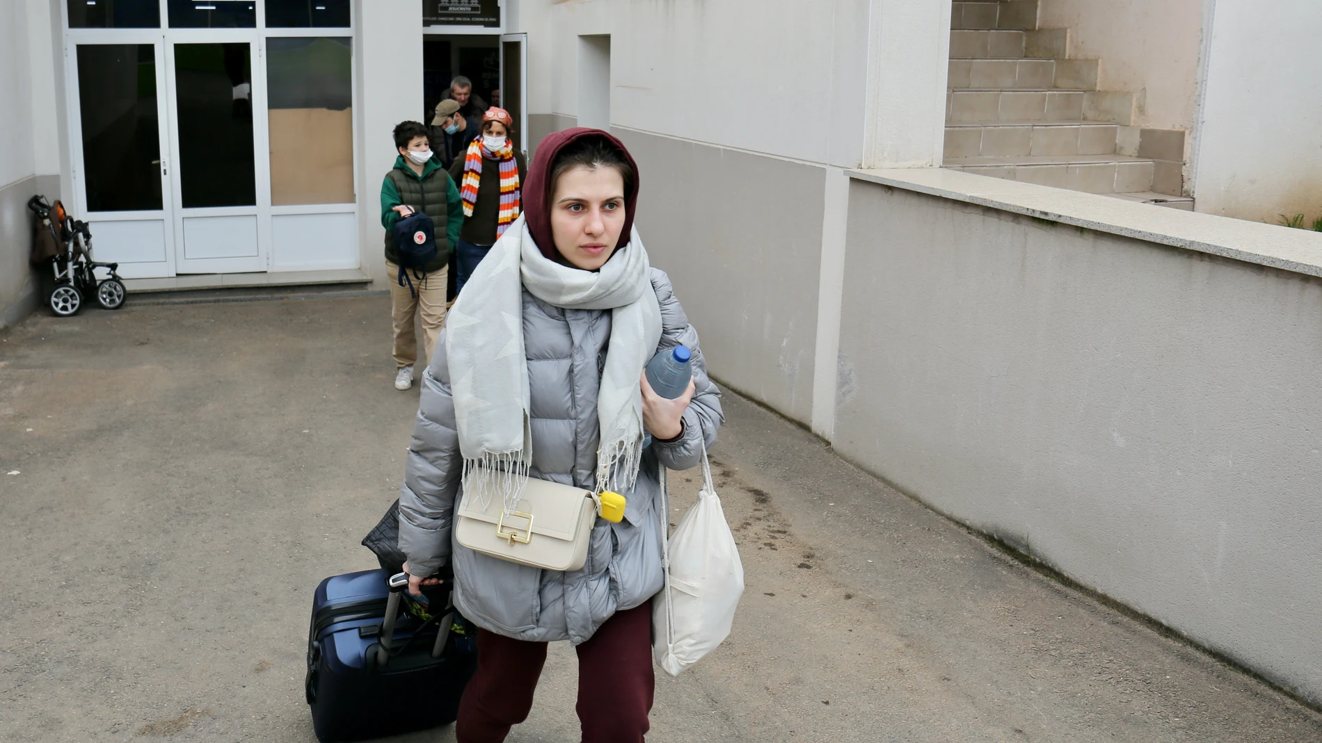 Una mujer y varios niños refugiados, en la sede de REMAR en Madrid, van hacia el autobús que les llevará a la estación Sur madrileña, desde donde partirán a otros destinos, tras haber finalizado un viaje organizado por REMAR RUMANÍA para escapar de Ucrania