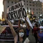 Una mujer sostiene un cartel que dice en español "Tribunal corrupto", mientras los manifestantes protestan contra la decisión de la Corte Constitucional de Perú que aprobó la liberación de prisión del expresidente Alberto Fujimori en Lima, Perú, el jueves 17 de marzo de 2022.