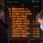 Pasajeros delante de un panel informativo en un anden de la estación de Chamartín, este lunes.