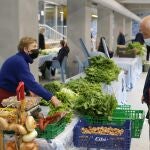 Una vendedora local de verduras y productos del campo vende sus productos en el mercado tradicional de la Plaza de Abastos de Lug