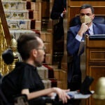 El presidente del Gobierno, Pedro Sánchez, escucha la intervención del líder de Podemos, Pablo Echenique (i), tras su comparecencia ante el pleno del Congreso