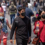 Personas caminan con mascarillas por las calles de una ciudad