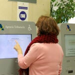 Una mujer recoge su turno en una oficina de la Agencia Tributaria
