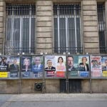Un hombre pasa por una calle con carteles electorales en Burdeos