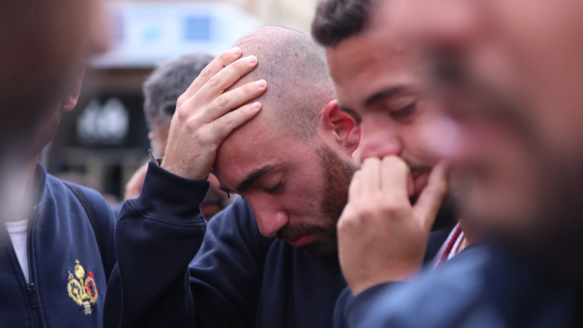 Dos costaleros de la Hermandad de San Benito emocionados tras la suspensión de Estación de Penitencia, en la Semana Santa de Sevilla de 2022