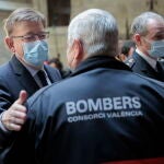 El president de la Generalitat, Ximo Puig, conversa con un bombero durante la presentación este miércoles de la campaña contra incendios forestales "Stop al foc"