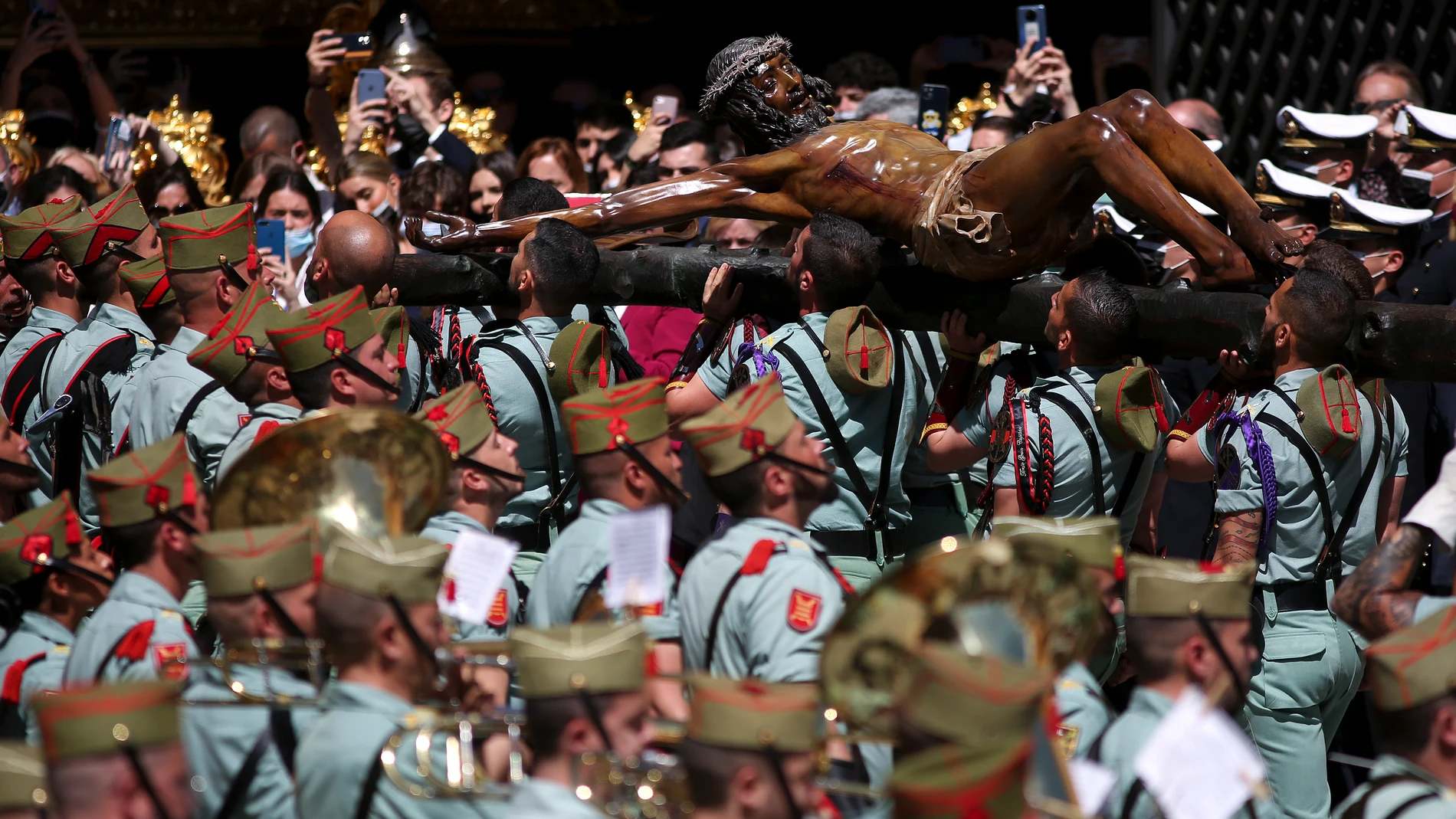 Legionarios del Tercio Gran Capitán, con sede en Melilla, llevan a hombros la figura del Cristo de la Buena Muerte y Ánimas mientras lo trasladan a la casa hermandad de la Cofradía de Mena este Jueves Santo en Málaga. EFE/Daniel Pérez