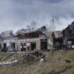 Los bomberos trabajan en la extinción de un incendio tras el impacto de un ataque aéreo en una tienda de neumáticos en Leópolis